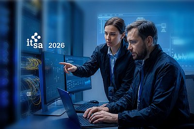 Zwei IT-Sicherheitsfachleute überwachen Computersysteme in einem Kontrollraum; daneben steht it-sa 2026