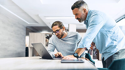 Zwei Männer vor einem Laptop