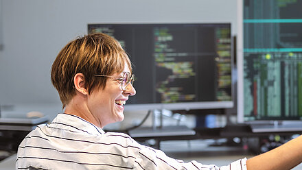 Portrait of a R&S Networks and Cybersecurity employee in front of your computer
