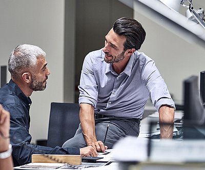 Des collaborateurs discutent à un bureau