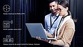 Deux collaborateurs regardent un ordinateur portable, à côté duquel sont représentés des icônes de vCPE, vWLC et vGateways.