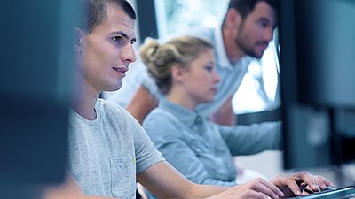 Employees look at a screen