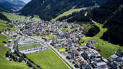 Photo of the municipality of Ischgl taken from above from an airplane: Idyllic houses and streets in the valley between the mountains