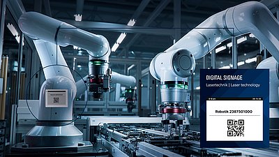 Robotic arms operate on a production line with digital signage and a QR code for laser technology.