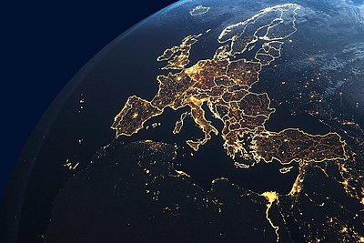 Nighttime satellite view of Europe from space, showing illuminated borders and a dense network of city lights