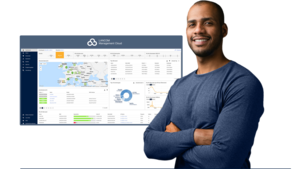 Man with folded arms in front of a screenshot from the R&S®LANCOM Management Cloud (R&S®LMC)