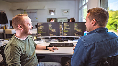 Software developer exchanging ideas at the PC