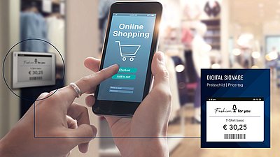 Person taps an online shopping app on a smartphone beside a digital price tag.