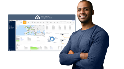Man with folded arms in front of a screenshot from the R&S®LANCOM Management Cloud (R&S®LMC)