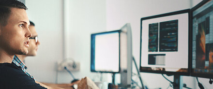 Young IT employee in front of a computer screen