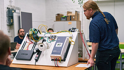 Rohde & Schwarz Networks and Cybersecurity Experte Lukas Nacke vor einem IT-Modell